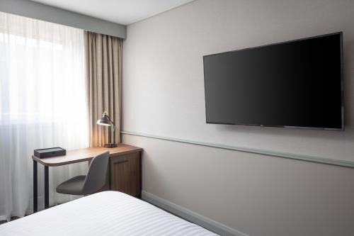 a hotel room with a flat screen tv on the wall at Four Points by Sheraton Edinburgh in Edinburgh