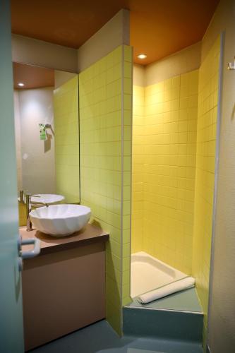 a bathroom with a white sink and a tub at greet hôtel Pont du Gard - Route d'Avignon in Estézargues