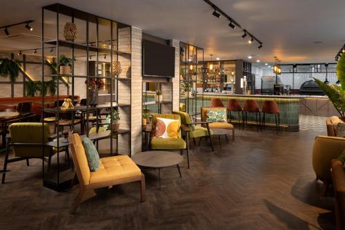 a restaurant with tables and chairs and a bar at Four Points by Sheraton Edinburgh in Edinburgh