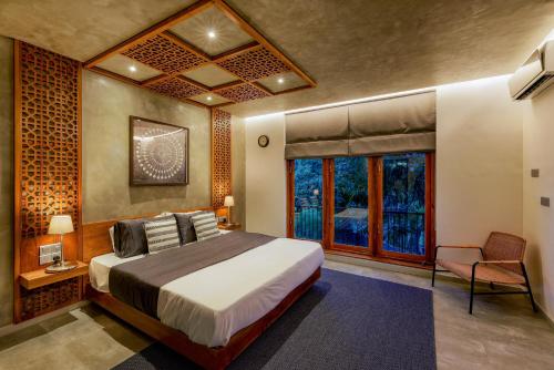 a bedroom with a bed and a chair and a window at LAKE VILLA by CARLSEN in Moratuwa