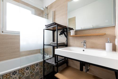 un baño con lavabo y bañera en Landaise le lagunak avec piscine chauffée à 900 M de la plage, en Labenne