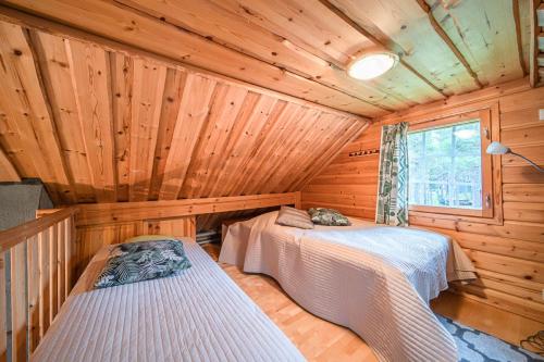 a bedroom with two beds in a wooden cabin at Immelkolo in Levi
