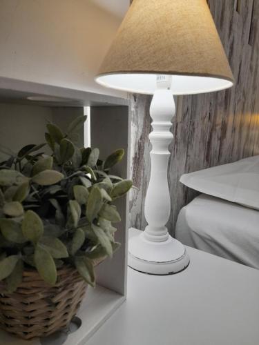 a lamp sitting on a table next to a plant at Il Mare Di Roma in Lido di Ostia