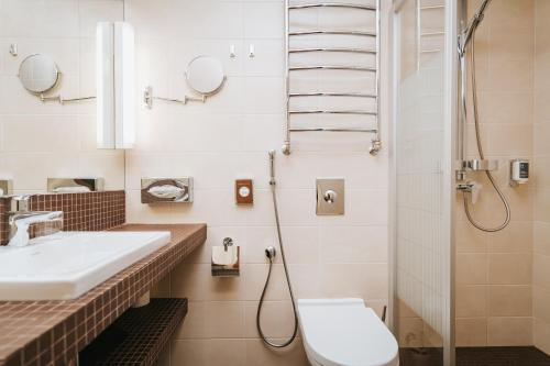 a bathroom with a sink and a shower and a toilet at Hestia Hotel Haapsalu SPA in Haapsalu