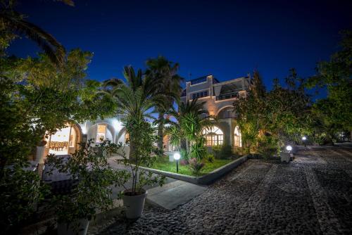 a building with trees in front of it at night at Pantheon Hotel in Perivolos