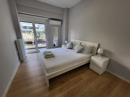 een witte slaapkamer met een bed en een raam bij Spacious Apartment In N. Smirni in Athene