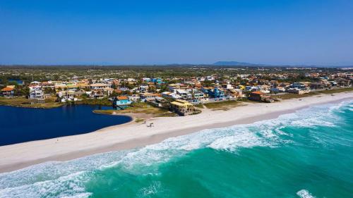 カボ・フリオにあるCasa Blanca 3 suítes Praia Lagoa SPA aquecido Piscinaの海と家の空の景色