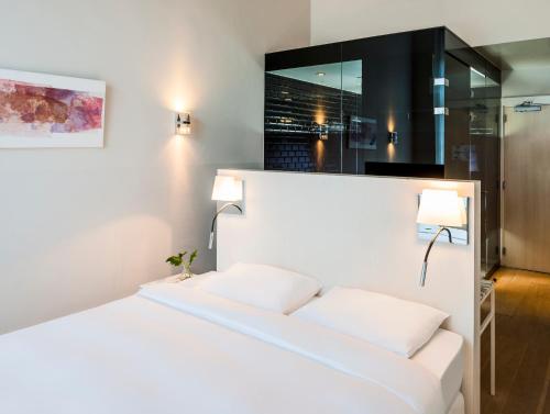 a bedroom with a white bed with two pillows at Hotel Arena in Amsterdam