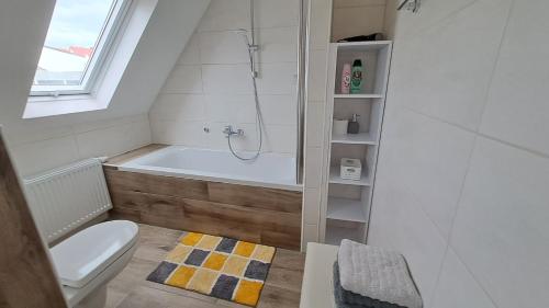 La salle de bains est pourvue de toilettes et d'une baignoire. dans l'établissement Ferienwohnung am Altmühlsee, à Gunzenhausen