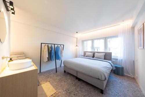 a bedroom with a bed and a sink and a mirror at Luxury Design Apartment with free private parking in Ostend