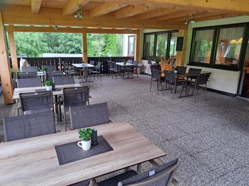 un patio al aire libre con mesas, sillas, mesas y sillas en Gasthof Leitner - Der Wirt an der Klamm, en Donnersbach