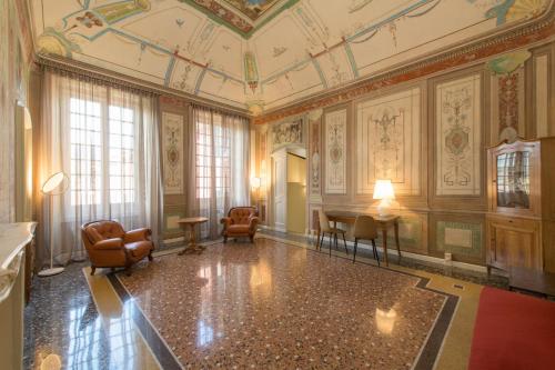 Habitación decorada con sillas y mesa. en Palazzo Sertorio Suites, en Gavi