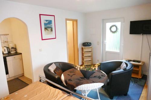 ein Wohnzimmer mit 2 Stühlen und einem Tisch in der Unterkunft Ferienappartement Grund in Ahlbeck