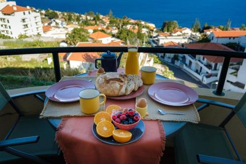 - une table avec de la nourriture et des fruits sur un balcon dans l'établissement GuestReady - An amazing stay with Island views, à Caniço