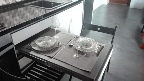 a table with plates and wine glasses on it at Vivienda Vacacional San Roque, 30 in Garachico