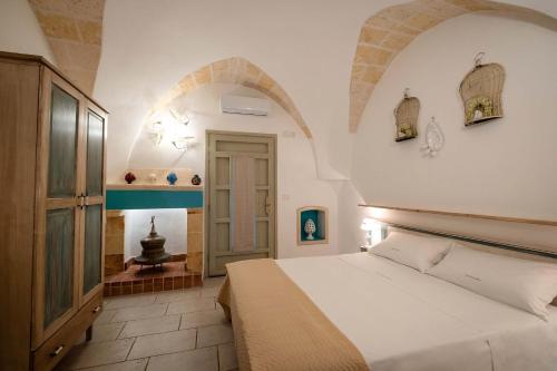 ein Schlafzimmer mit einem weißen Bett in einem Zimmer mit Bögen in der Unterkunft Tenuta Donna Caterina by BarbarHouse in Mesagne