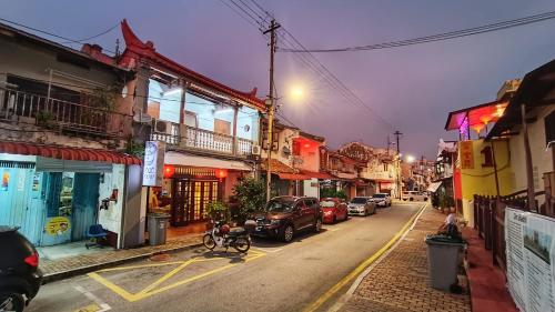 uma rua da cidade com carros estacionados na rua em Wau Sayang Sayang Guest House em Malaca