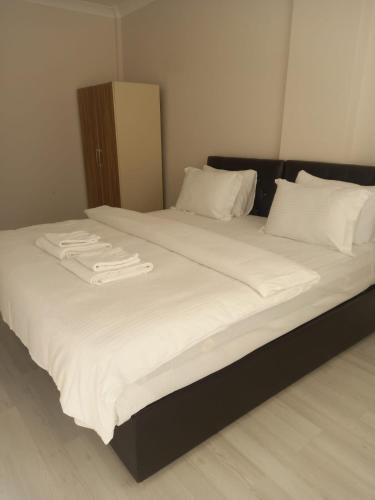 ein großes Bett mit weißer Bettwäsche und weißen Kissen in der Unterkunft PEKER Apart in Pelitli