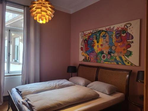 Schlafzimmer mit einem Bett mit Wandgemälde in der Unterkunft Am Thalia Designe Apartment in Baden-Baden