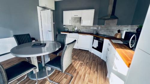 a kitchen with a table and chairs in a room at The King's Tower in Whitehead