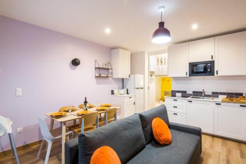 une cuisine et une salle à manger avec un canapé et une table dans l'établissement Lavie Maison Chic Stay AC Parking, à Paris