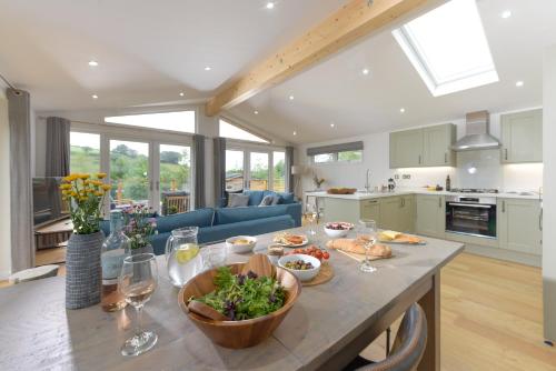 a kitchen and living room with a table with food at 4 Valley View in Looe