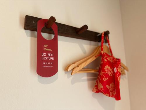 a do not disturb sign and a bag on a wall at Baan Daeng Resort บ้านรักไทย in Ban Rak Thai