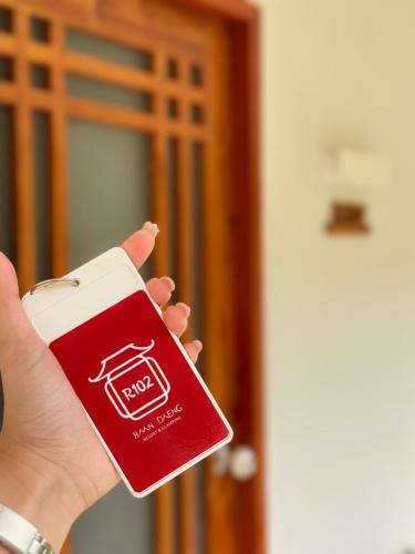 a person holding a red and white card in their hand at Baan Daeng Resort บ้านรักไทย in Ban Rak Thai