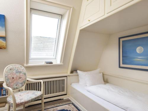 a small bedroom with a window and a chair at Nautilus-12 in Kampen