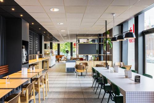 a restaurant with tables and chairs and a person in the background at ibis Strasbourg Centre Les Halles in Strasbourg