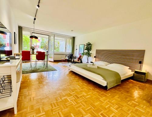 New, central studio with garden terrace and much privacy في زيورخ: غرفة نوم مع سرير وغرفة معيشة