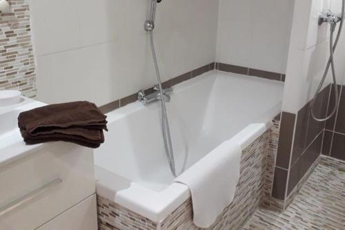 une salle de bain avec une baignoire avec une serviette dessus dans l'établissement Appart dans villa Port Fréjus 2, à Fréjus