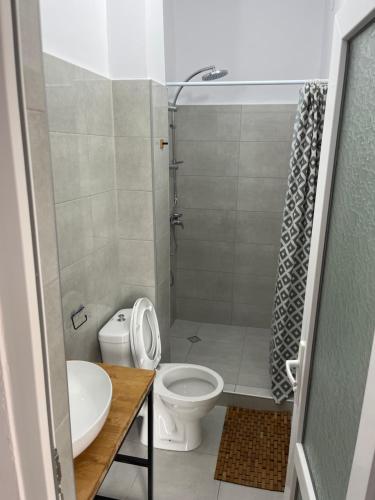 a small bathroom with a toilet and a sink at Ureki Hotel Olympia Family Room in Ureki