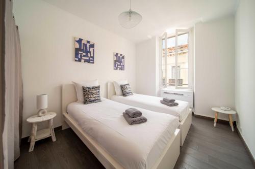 une chambre avec deux lits et une fenêtre dans l'établissement Bright beautiful apartment - city center Cannes, à Cannes