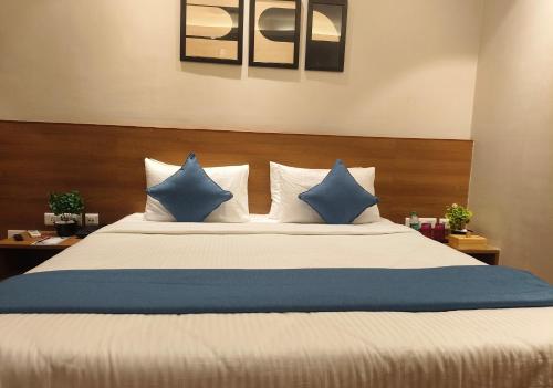 a bedroom with a bed with blue and white pillows at CENTRAL INN in Dibrugarh