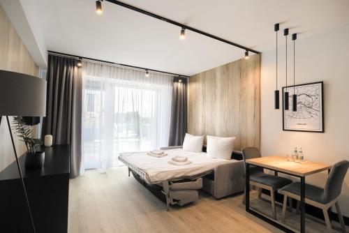 a bedroom with a bed and a table and chairs at AboutArtApartments - Otyńska 4 in Wrocław