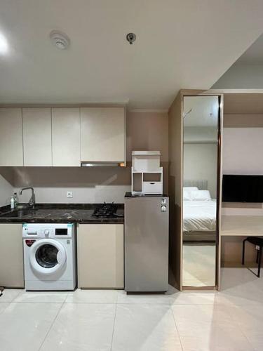 eine Küche mit einem Kühlschrank und einem Bett in der Unterkunft Green Sedayu Apartment - Studio By PSG Grup in Jakarta