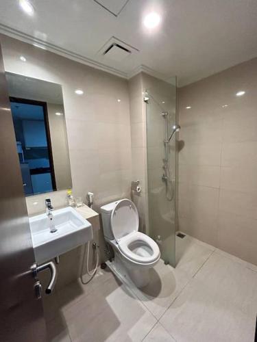 y baño con aseo, lavabo y ducha. en Green Sedayu Apartment - Studio By PSG Grup, en Yakarta