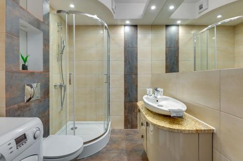 a bathroom with a shower toilet and a sink at Chmielna Park 5 TriApart® in Gdańsk