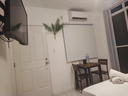 um quarto com uma cama, uma mesa e uma porta em Bonsai Jacuzzi Suites em Panglao