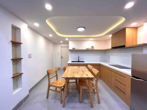 a kitchen with a wooden table and some chairs at Central, Minimalist and Cozy - Gau's House in Da Nang