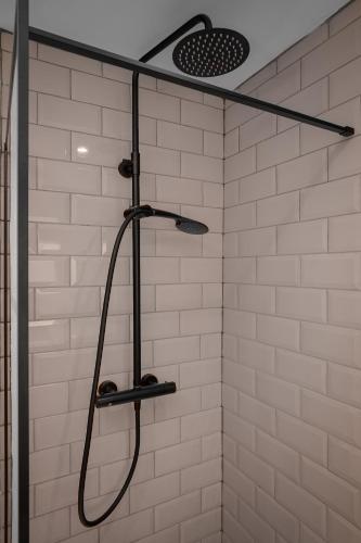 a shower with a shower head in a bathroom at St Chads Suites by Central Beach Leisure in Blackpool