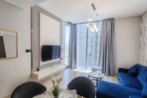 a living room with a blue couch and a large window at STAY BY LATINEM Luxury 1BR Holiday Home CVR A703 near Burj Khalifa in Dubai