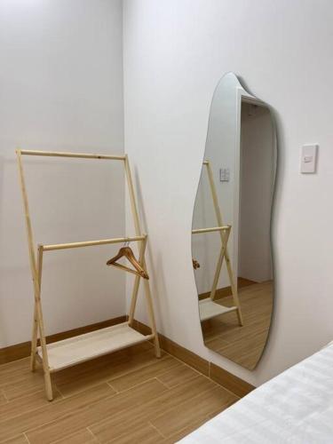 a mirror on a wall next to a bed at Central, Minimalist and Cozy - Gau's House in Da Nang