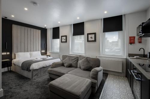 a bedroom with a bed and a couch and a bed and a bed at St Chads Suites by Central Beach Leisure in Blackpool