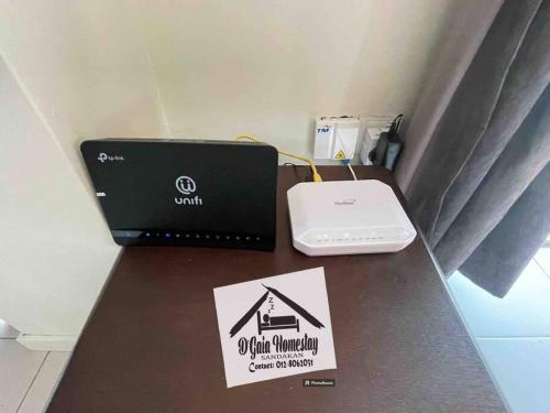 a table with a laptop and a sign on it at D'gaia Ujana Homestay Sandakan in Sandakan