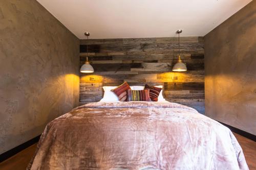 a bedroom with a large bed and two pendant lights at Fermain Valley Hotel in St. Peter Port