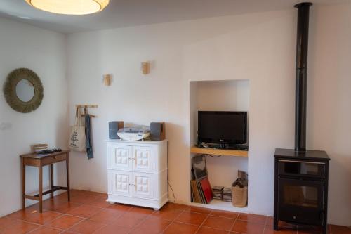 ein Wohnzimmer mit einem Flachbild-TV und einem TV-Stand in der Unterkunft Casa dos Marianinhos in Elvas