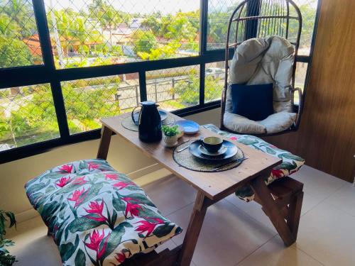 una mesa y una silla en una habitación con ventana en Guarajuba , Lindíssimo Paraíso dos Coqueiros en Camacari