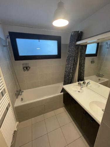 une salle de bain avec une baignoire, un lavabo et une fenêtre dans l'établissement Unique Proche Vieux Port, plage et centre avec Parking privé, à Marseille